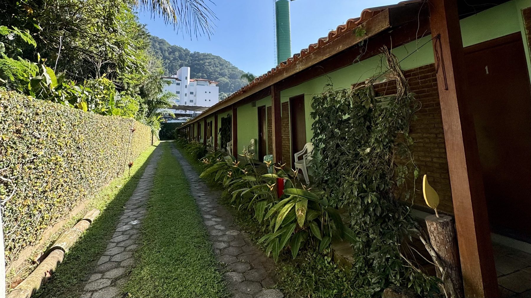 Fachada verde dos quartos com a montanha ao fundo