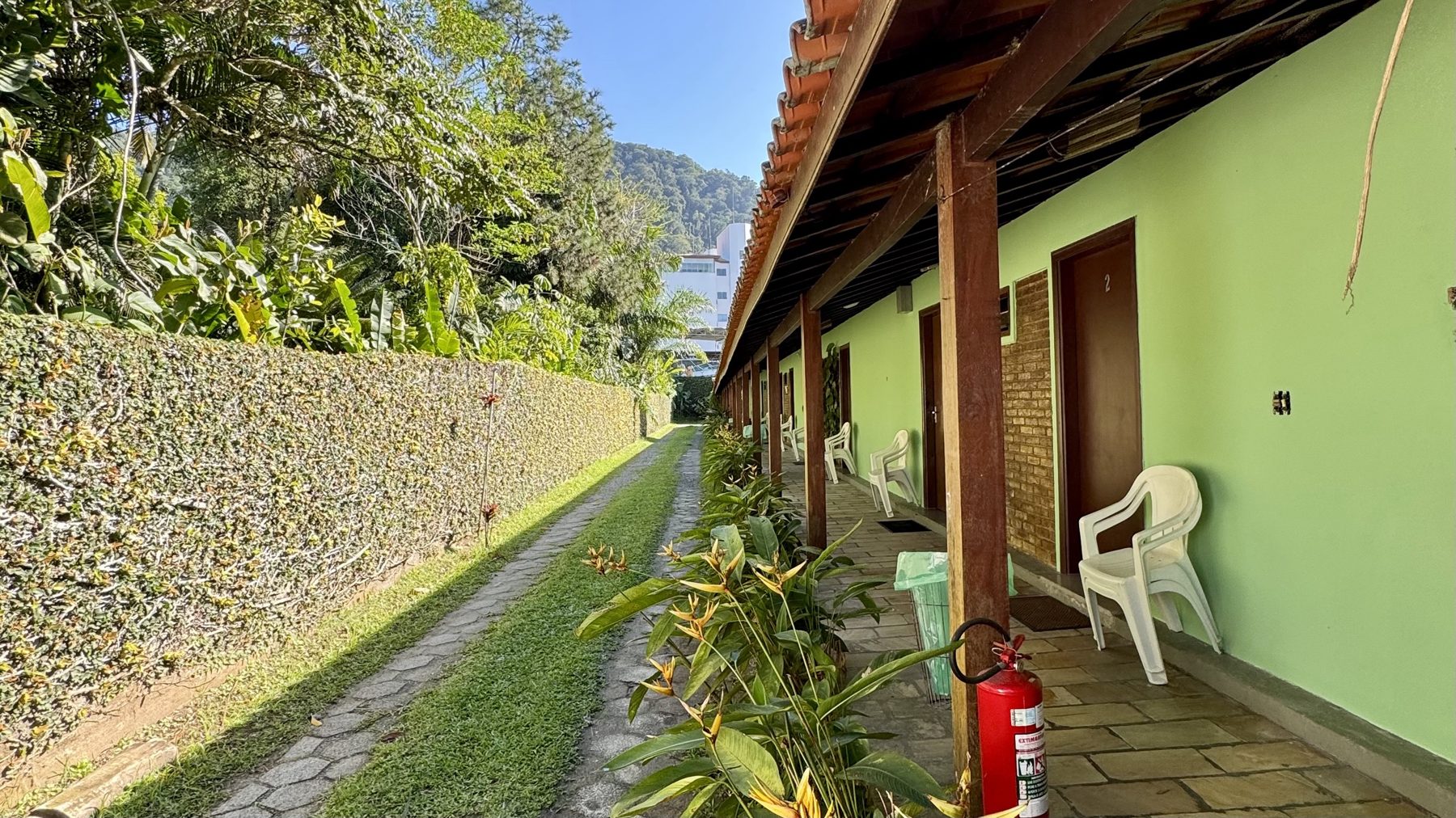 Varanda coberta dos quartos com cadeiras e jardim