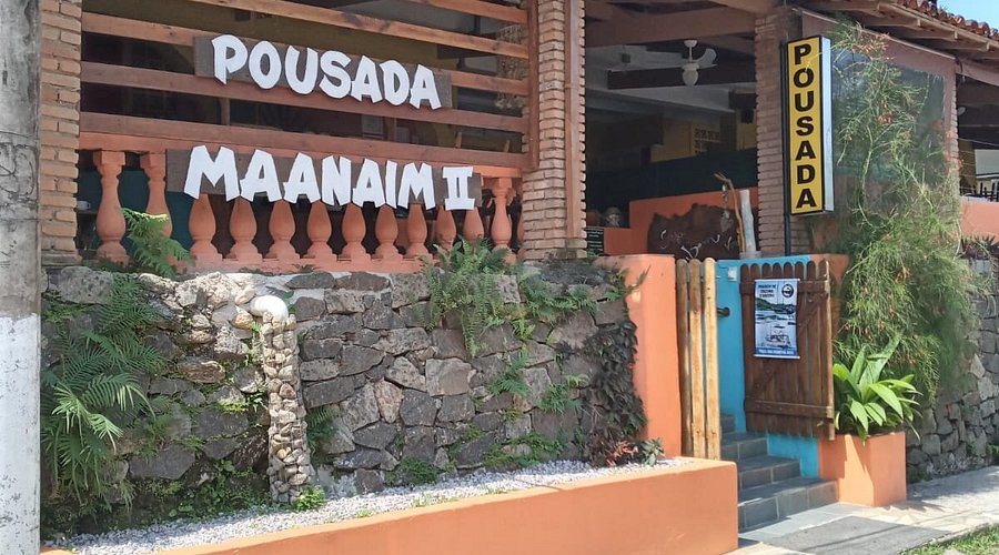 Fachada da Pousada Maanaim II com muro de pedra e portão de madeira