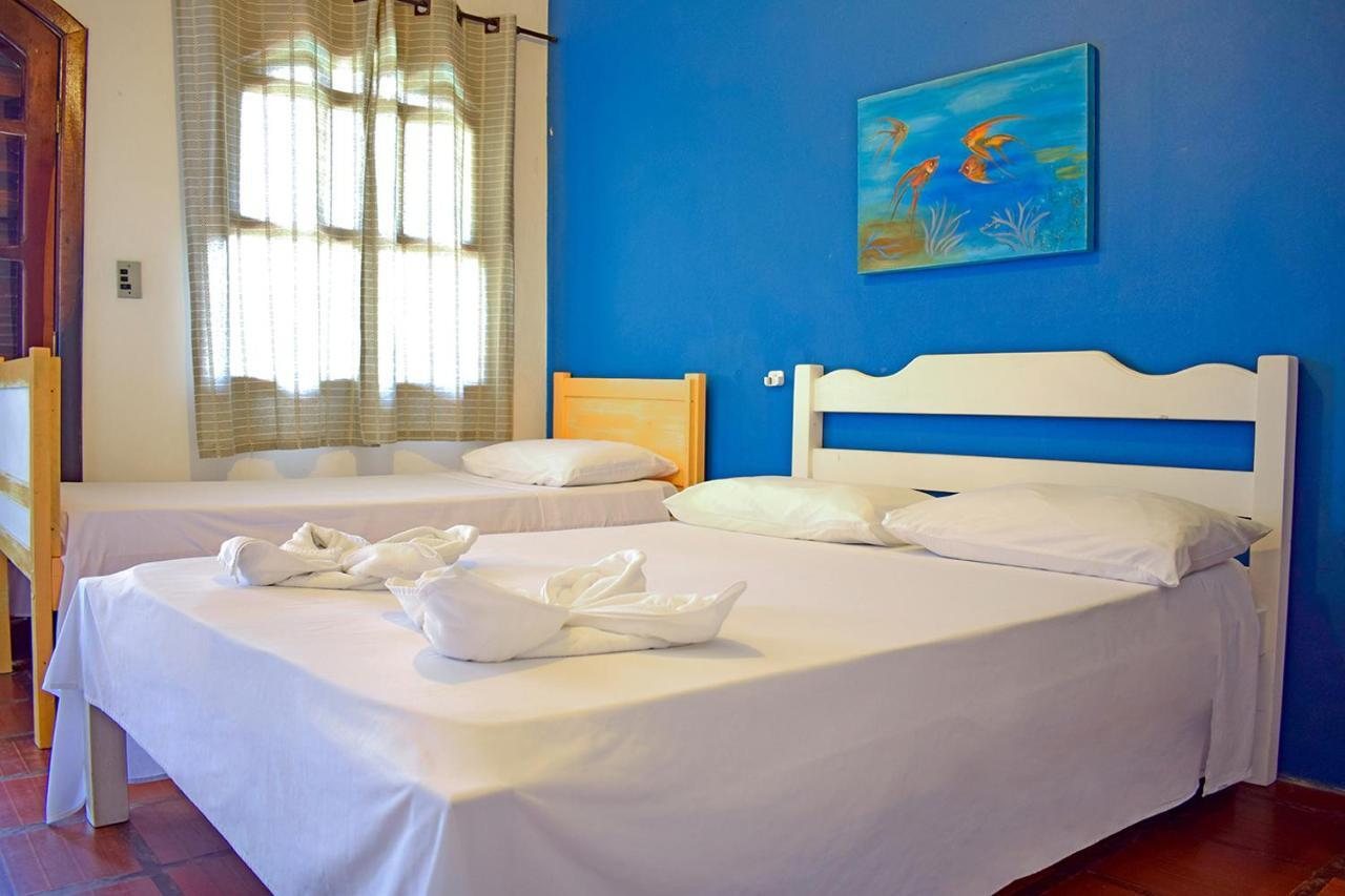 Quarto com parede azul, cama de casal e cama de solteiro