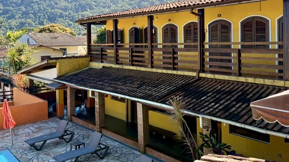 Varandas de madeira do andar de cima e espreguiçadeiras no pátio