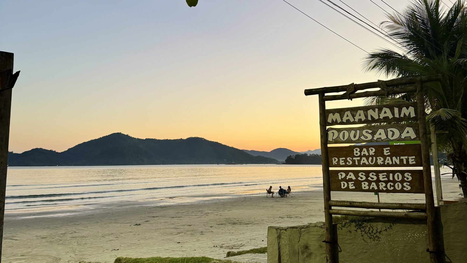 Pôr do sol na praia em Ubatuba, com montanhas ao fundo
