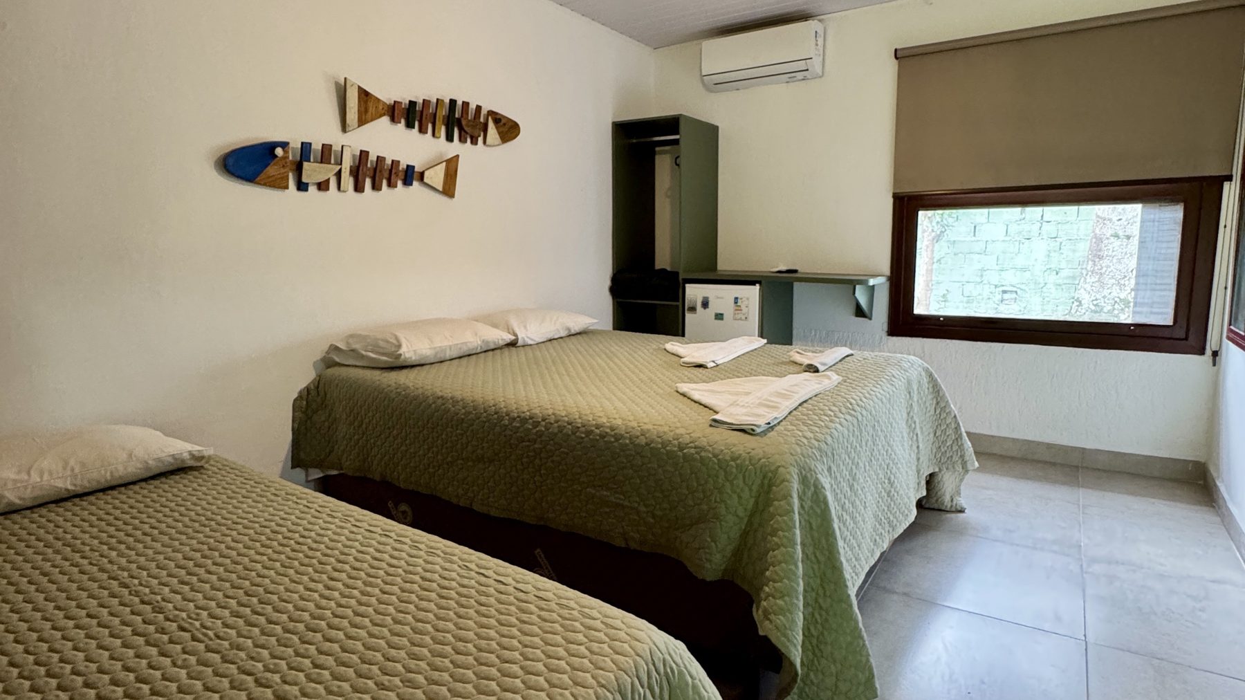 Quarto com cama de casal, cama de solteiro, ar-condicionado e frigobar
