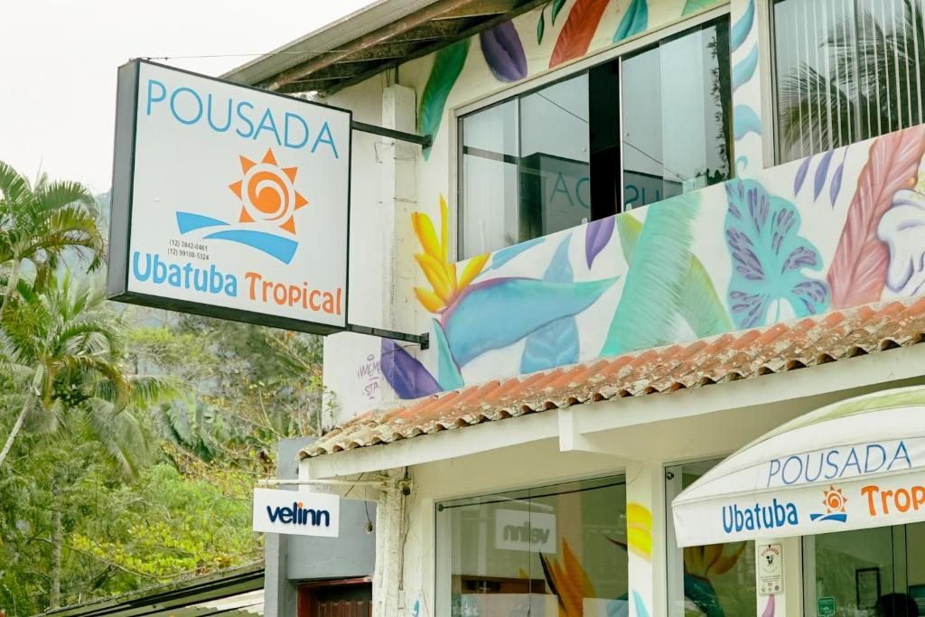 Fachada colorida com a placa da Pousada Ubatuba Tropical